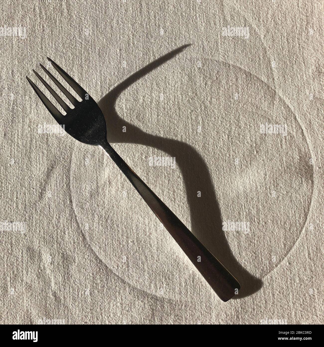 Fourche avec grande ombre sur la table du restaurant, vue sur le dessus Banque D'Images Fourche avec grande ombre sur la table du restaurant, vue sur le dessus Banque D'Images