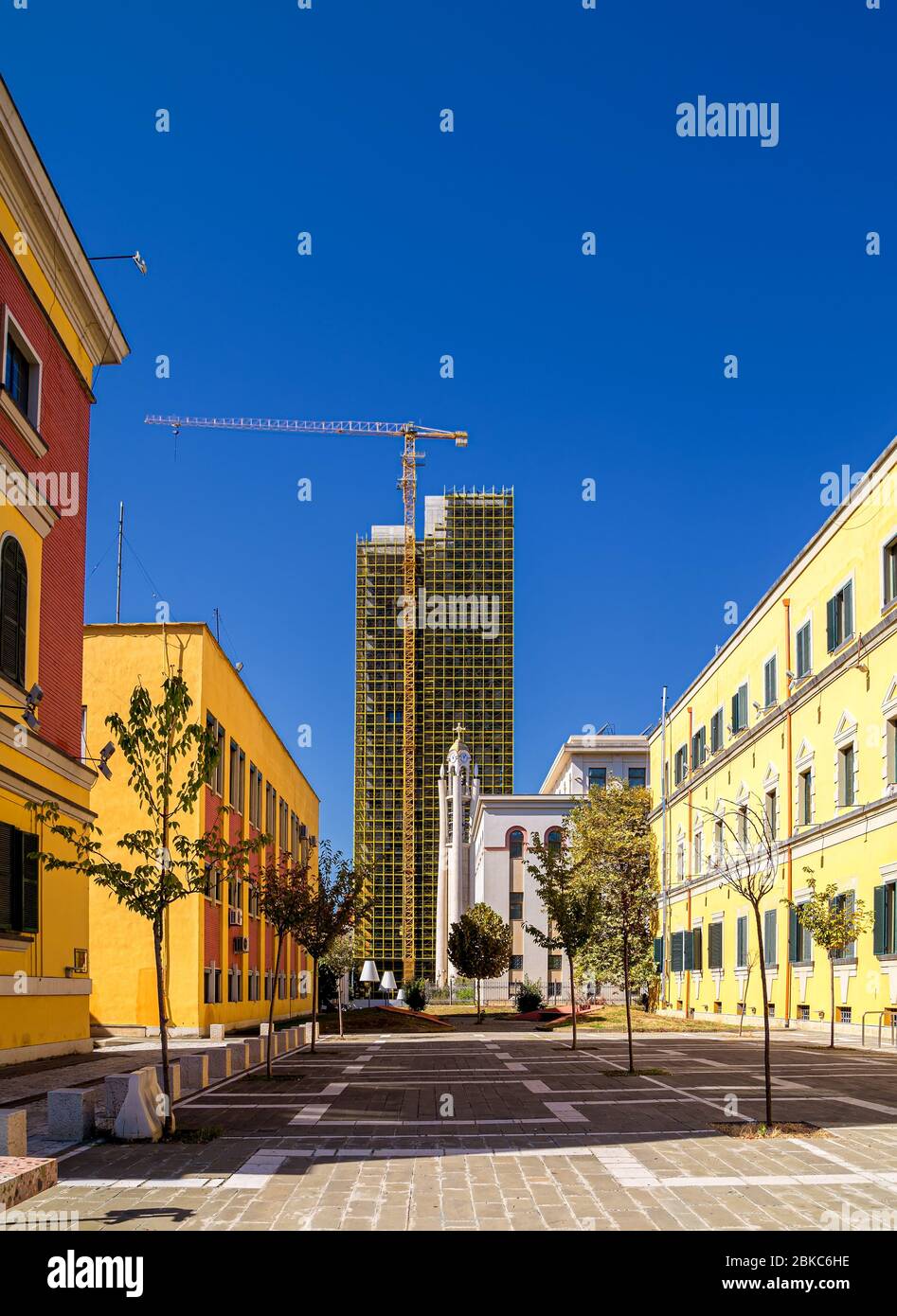 Vue sur la tour orthodoxe de l'Église autocéphale entre les bâtiments du Ministère des finances et du Ministère de l'énergie et de l'industrie de l'Albanie. Banque D'Images