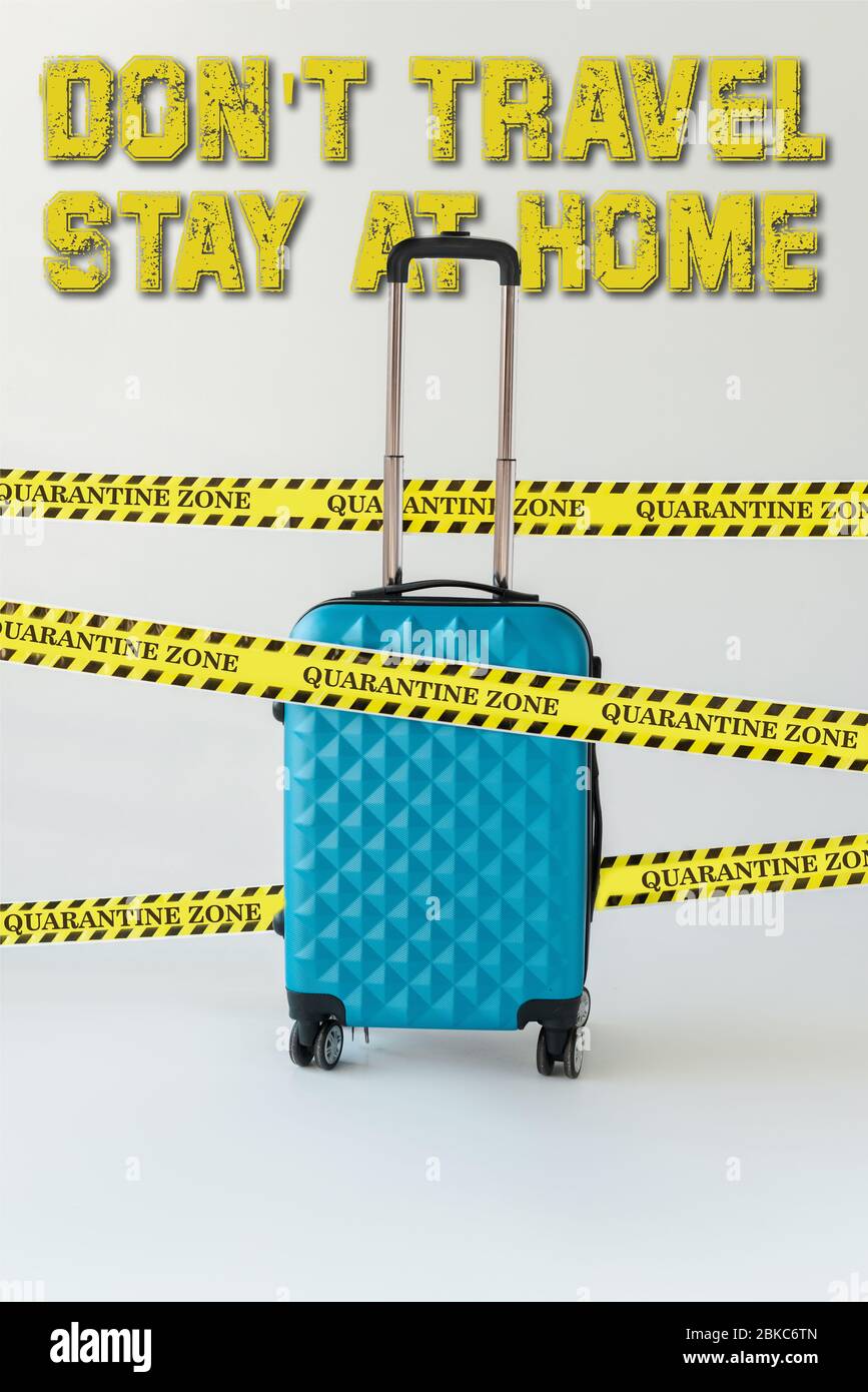 valise bleue en ruban de sécurité jaune et noir sur blanc, ne pas voyager,  rester à l'illustration de la maison Photo Stock - Alamy