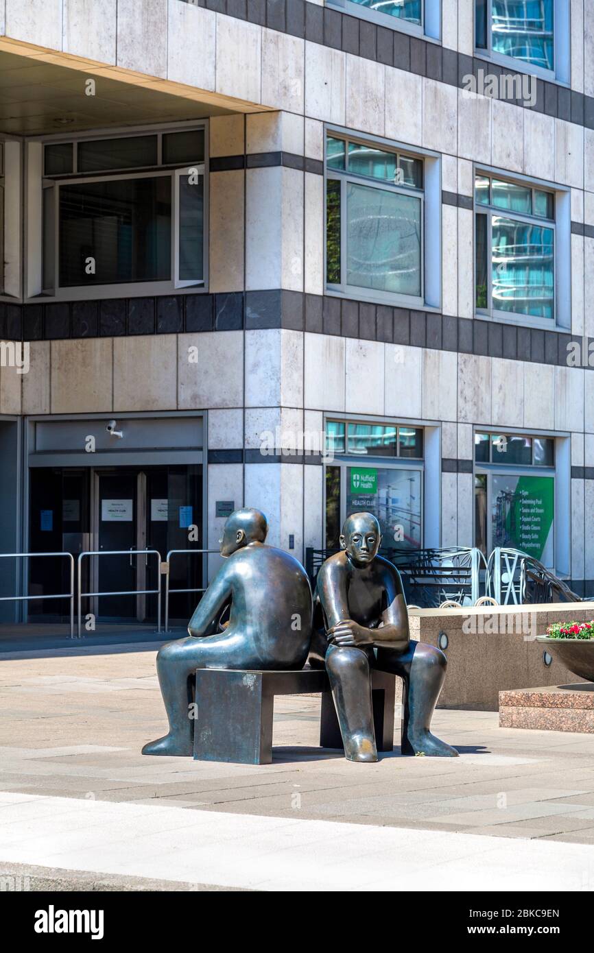 Sculpture en bronze « Two Men on a Bench » de Giles Penny à Canary Wharf, Londres, Royaume-Uni Banque D'Images