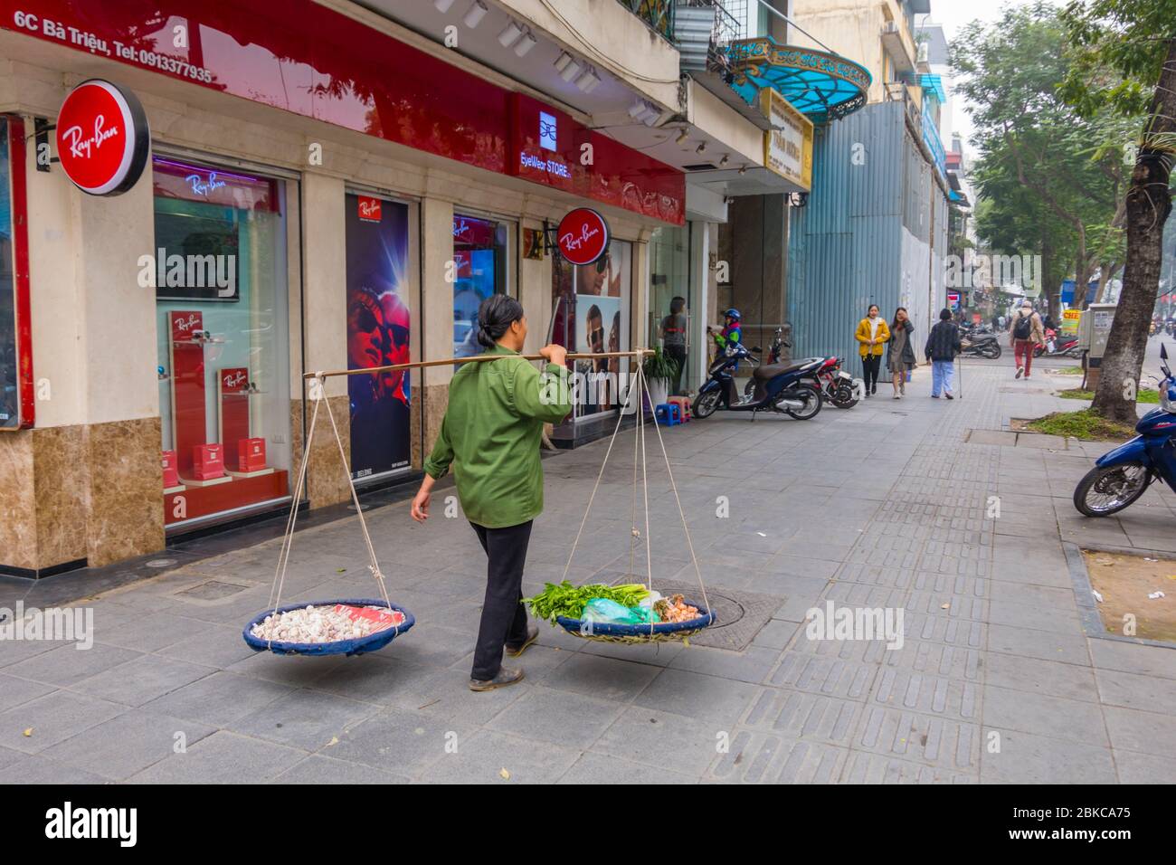 Vendeur de rue avec un poteau d'épaule traditionnel, rue Ba Trieu, quartier français, Hanoi, Vietnam Banque D'Images