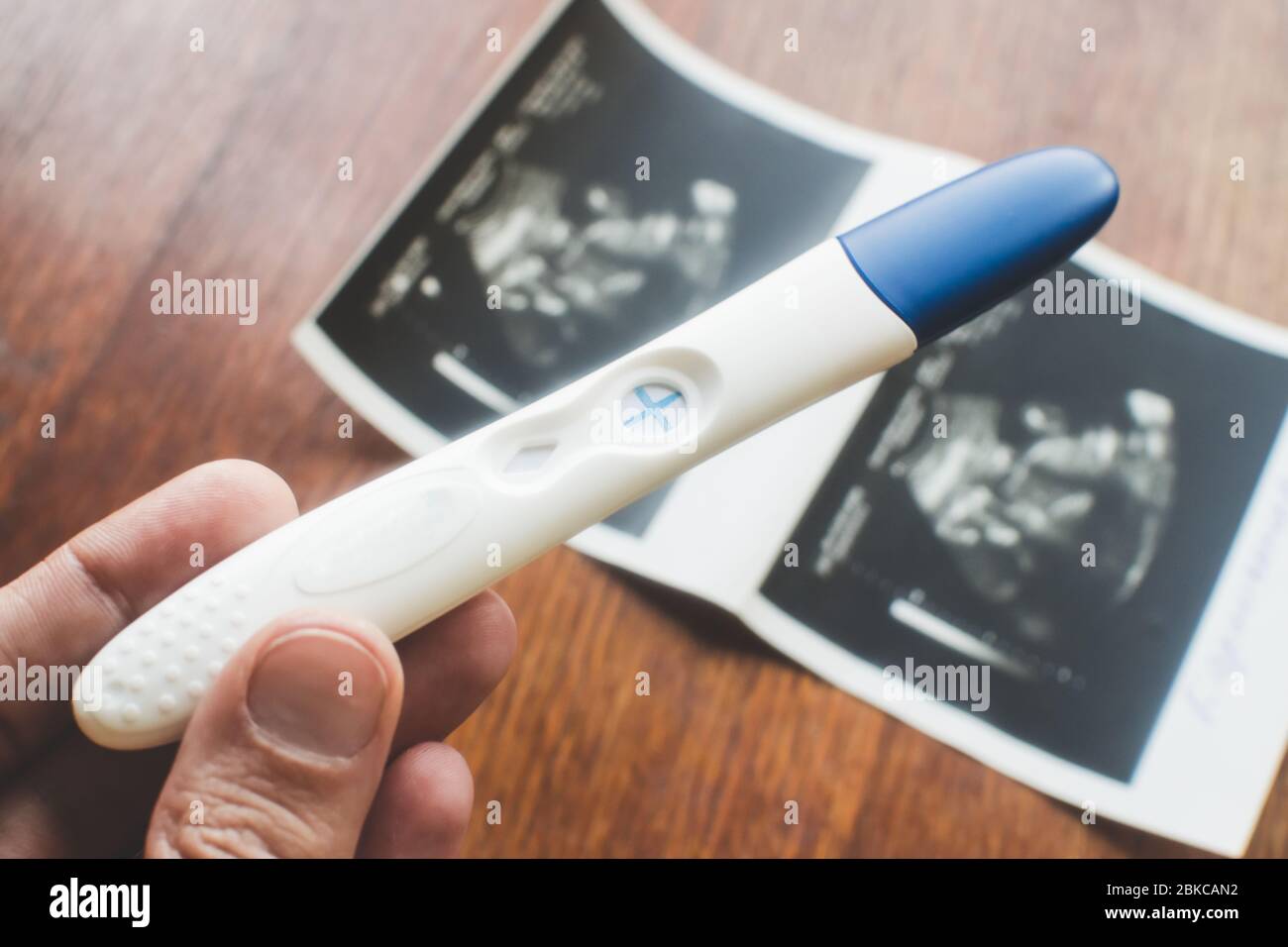 Test de grossesse positif dans la main des femmes. Banque D'Images