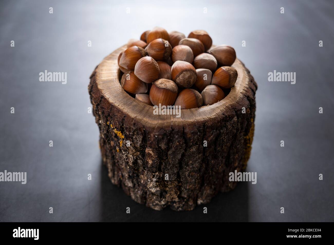 Noisettes dans un bol en bois et rustique. Noix crues et savoureuses pour en-cas. Nourriture saine, non torréfiée et délicieuse. Banque D'Images