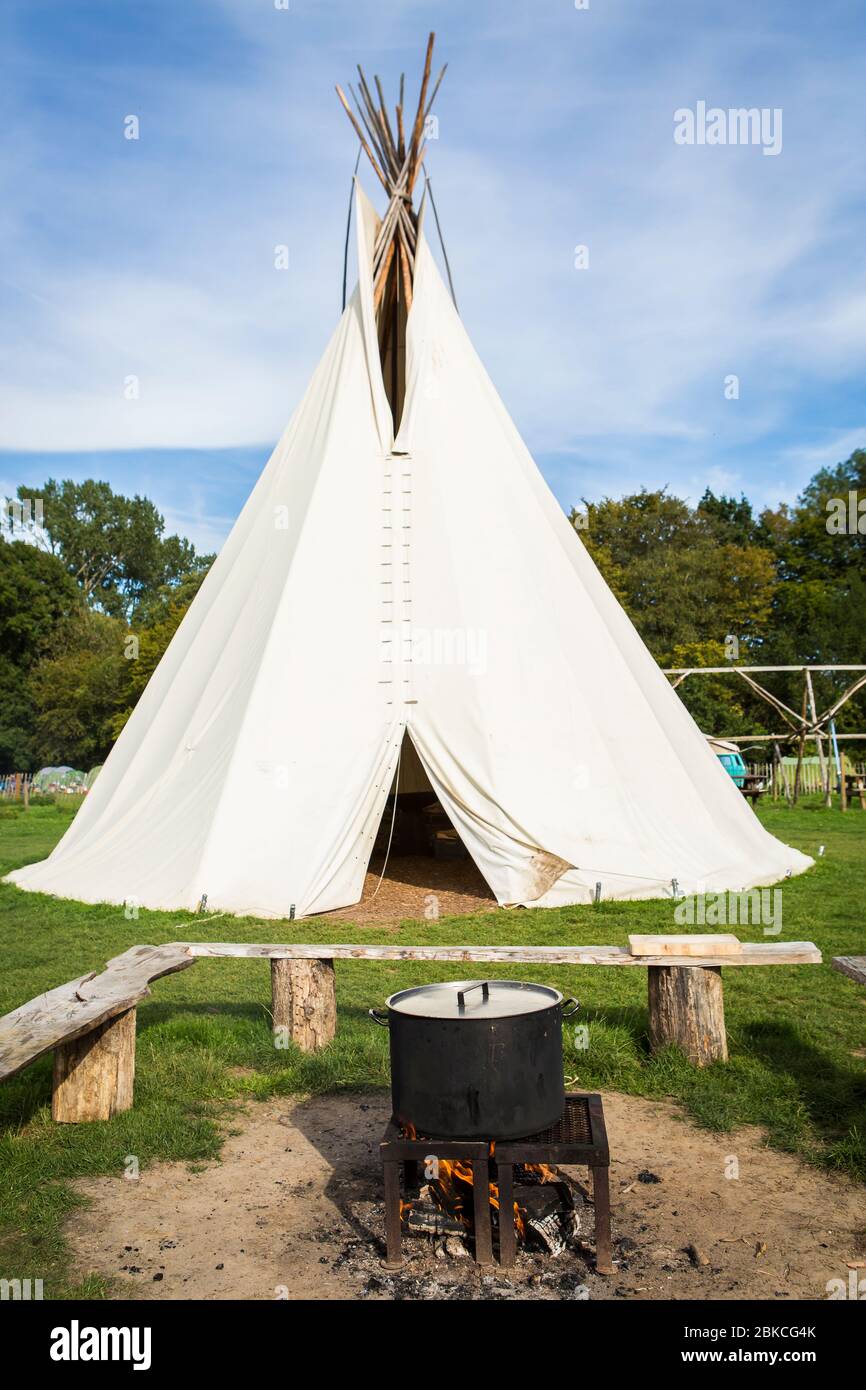 TIPI avec foyer et immense pot de cuisine sur feu à ciel ouvert à Wowo's, un camping familial dans le Sussex Banque D'Images