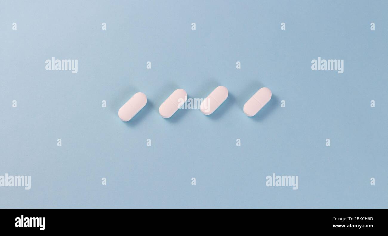 Pilules blanches sur fond bleu au centre. Copier pour texte Banque D'Images