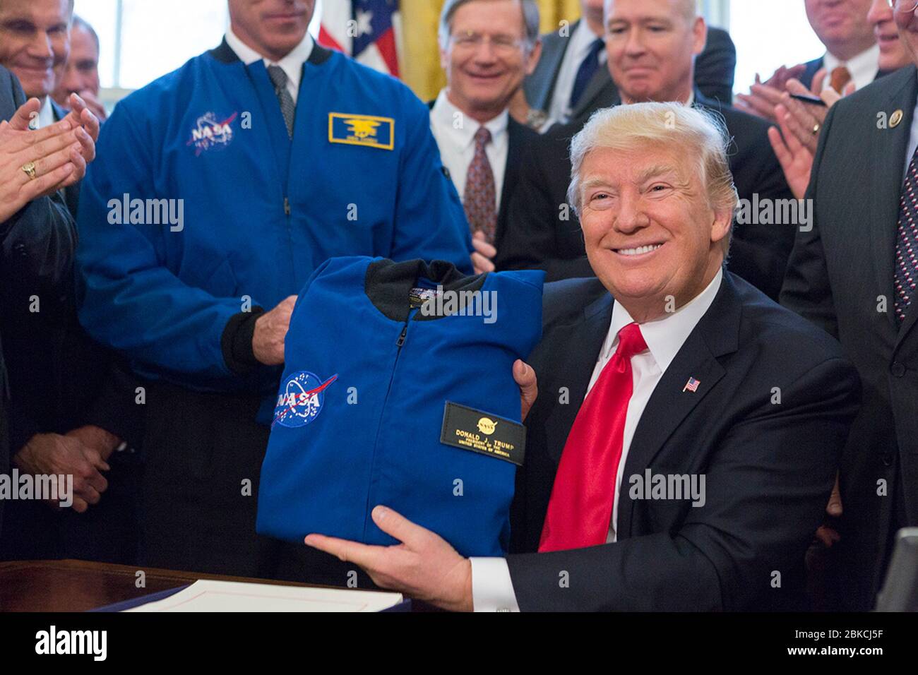 Le 21 mars 2017, le président Donald Trump a tendu une veste qui lui avait été donnée par un invité après avoir signé le S.422, la National Aeronautics and Space Administration transition Authorization Act, dans le bureau ovale. La loi autorisait les opérations de la NASA et dirigeait la politique spatiale et le financement futurs. Banque D'Images Le 21 mars 2017, le président Donald Trump a tendu une veste qui lui avait été donnée par un invité après avoir signé le S.422, la National Aeronautics and Space Administration transition Authorization Act, dans le bureau ovale. La loi autorisait les opérations de la NASA et dirigeait la politique spatiale et le financement futurs. Banque D'Images