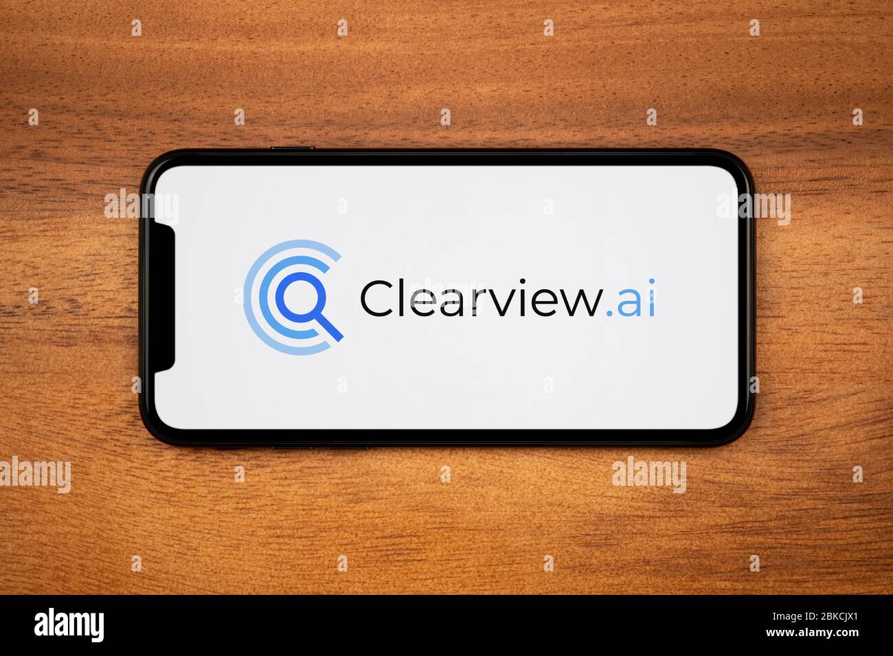 Un smartphone affichant le logo Clearview.ai repose sur une table en bois ordinaire (usage éditorial uniquement). Banque D'Images