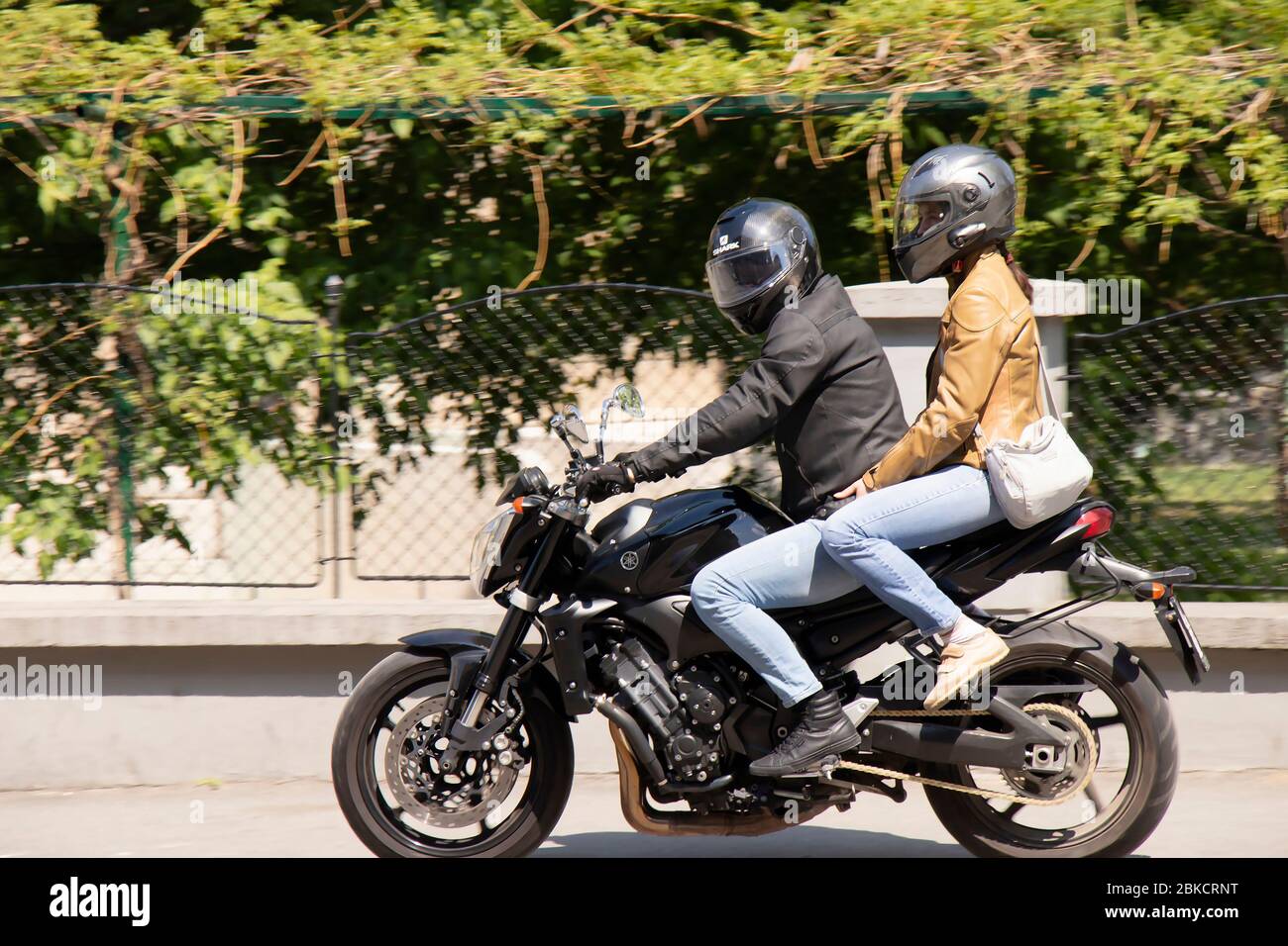 Belgrade, Serbie - 24 avril 2020: Un jeune couple qui monte sur un trottoir de la ville à moto Banque D'Images