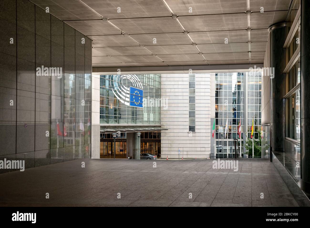 Parlement européen. Le symbole européen de la façade d'un bâtiment moderne. Drapeaux de l'Union européenne. Banque D'Images