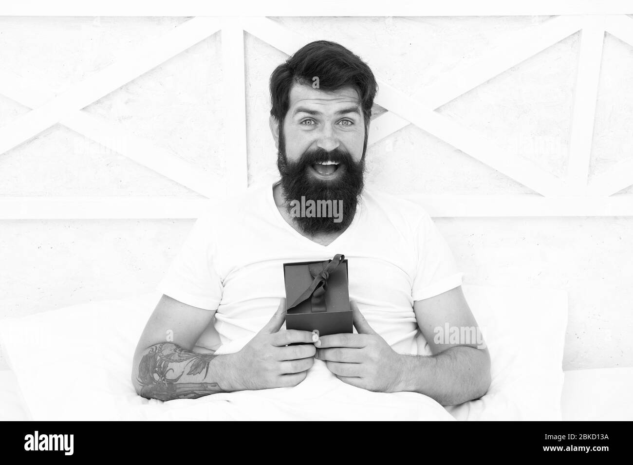Ouverte. cadeau pour la nuit. barbu passer à la maison de vacances. Jour de Valentines. Cadeau spécial. Heureux hipster avec présent fort au lit tôt le matin.. surprise jour démarrer avec message d'anniversaire. Banque D'Images
