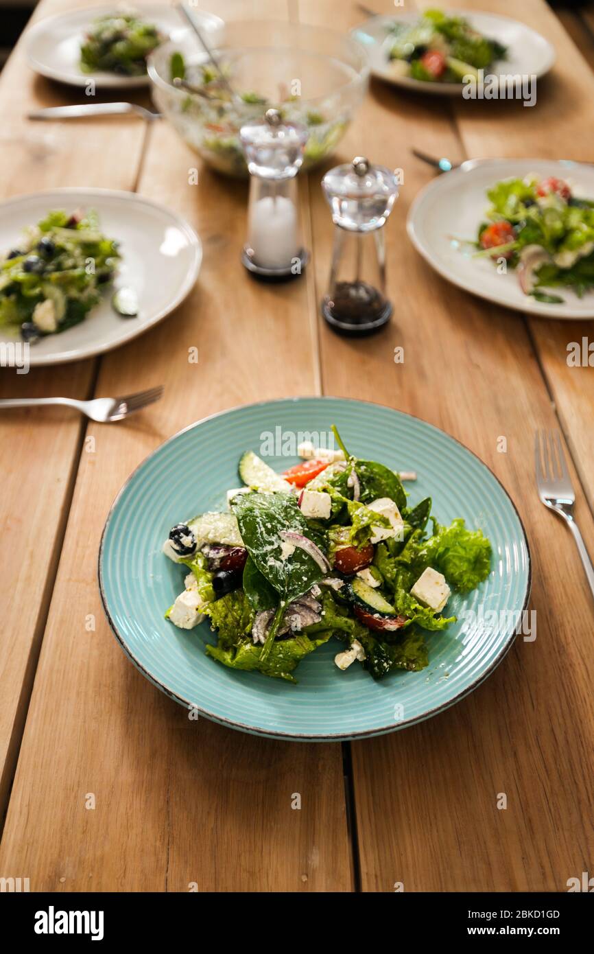 Table en bois avec assiettes à salade verte servies Banque D'Images
