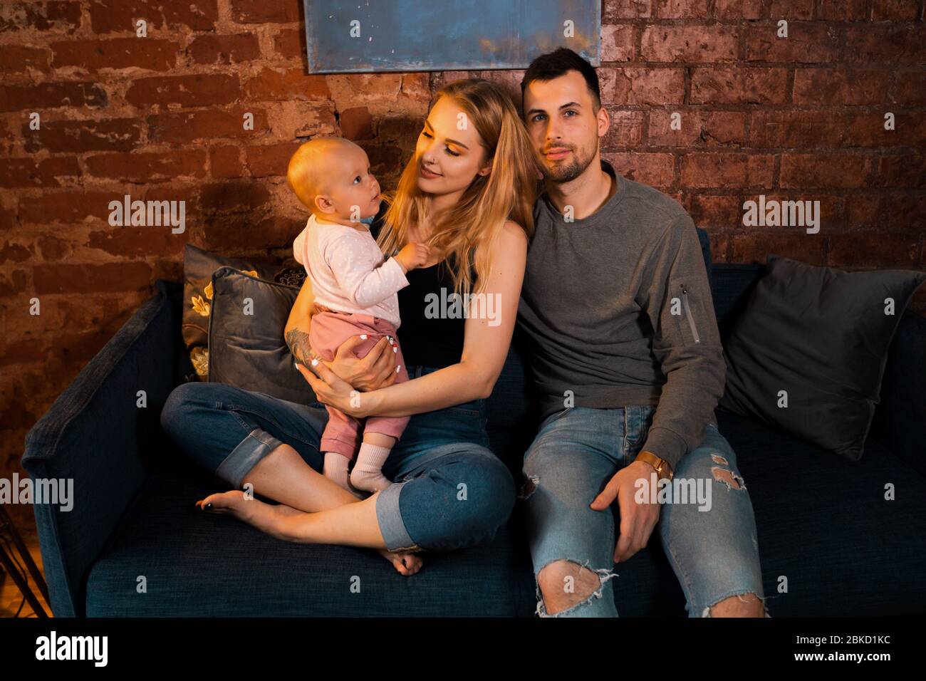 Les parents jouent et embrassent la fille en riant Banque D'Images