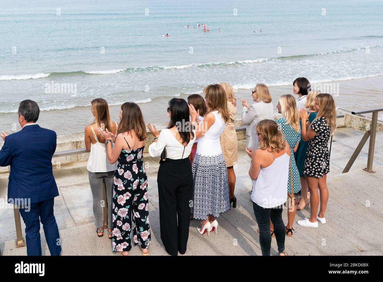 La première Dame Melania Trump, rejointe par les conjoints des dirigeants du G-7 et des athlètes et musiciens locaux, applaudit lors d'une manifestation de jeunes surfeurs lundi 26 août 2019, à la plage des Côtes des Basques de Biarritz, France. #G7Biarritz Banque D'Images
