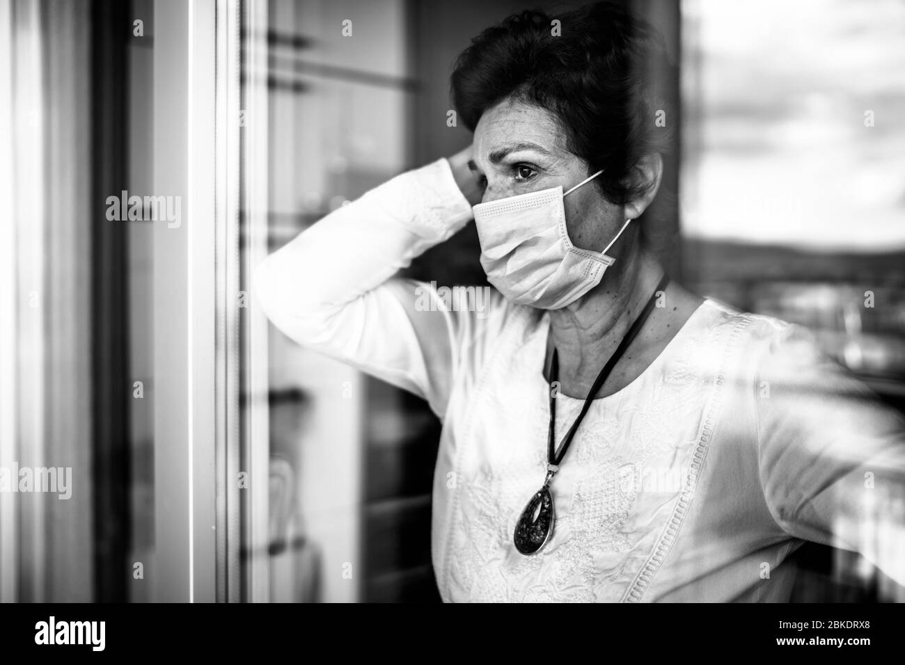 Personnes âgées âgées triste femme à la maison regardant par la fenêtre.Coronavirus COVID-19 risque d'infection de l'éclosion de maladie.Lockdown socialisation restriction ac Banque D'Images