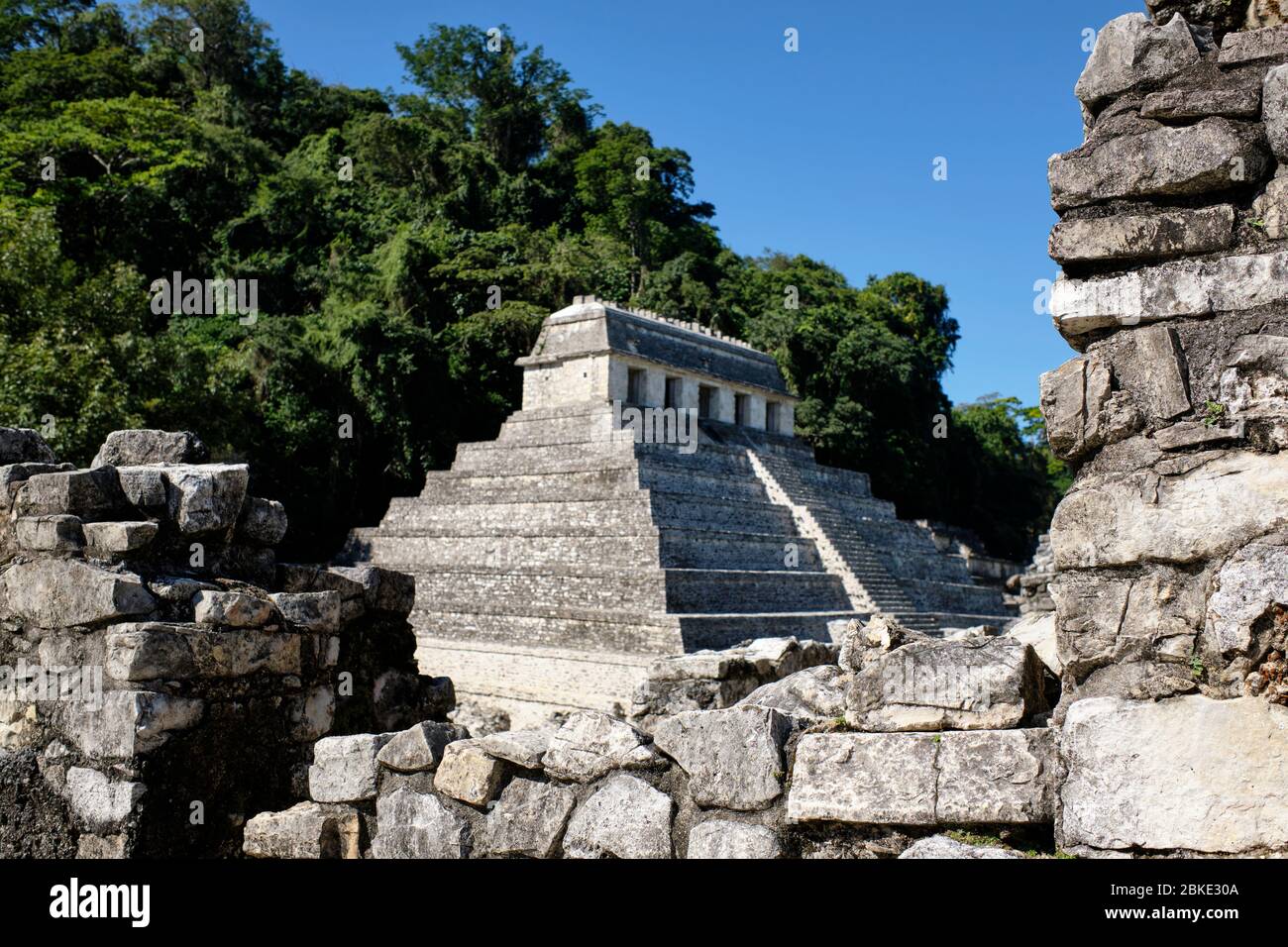 Pyramide Maya vue à travers les ruines d'un mur sur le site archéologique de Palenque. Banque D'Images