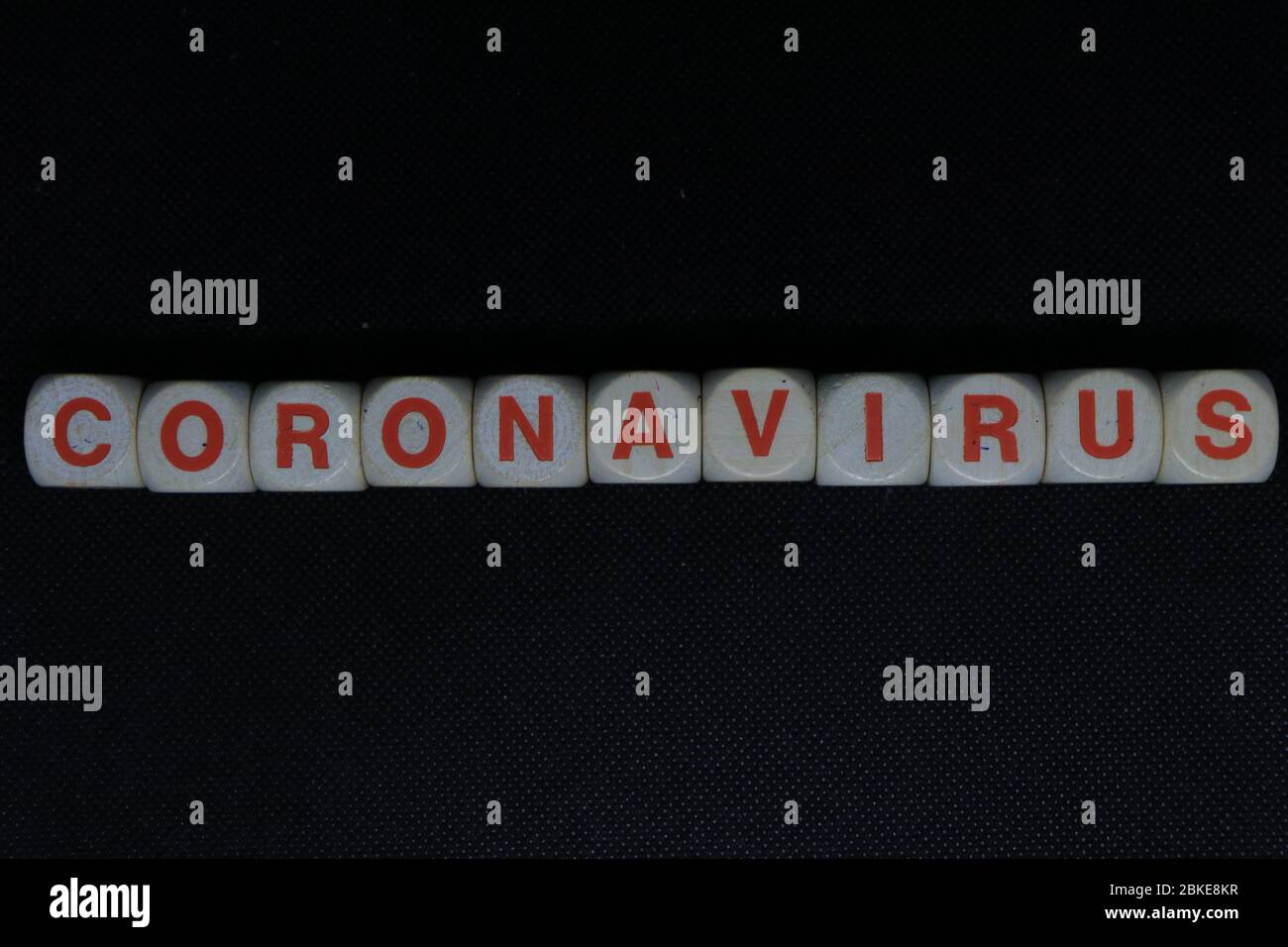 Lettres en bois orange et blanc dés formant l'écriture 'CORONAVIRUS' sur un fond noir. Le virus Corona danger nouvelles. Banque D'Images