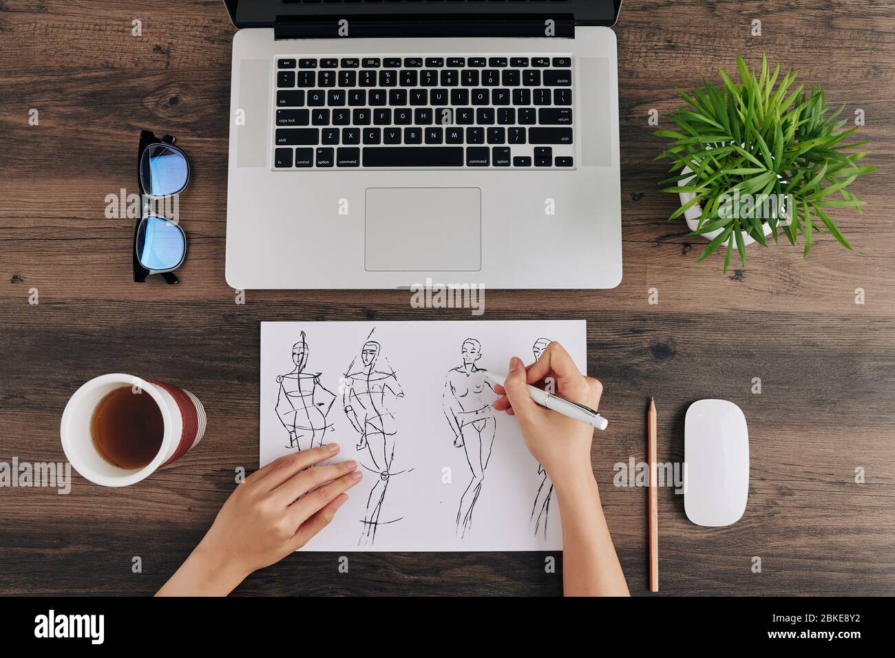 Un designer vous prépare une tasse de café en dessinant une illustration de la mode, vue d'en haut Banque D'Images