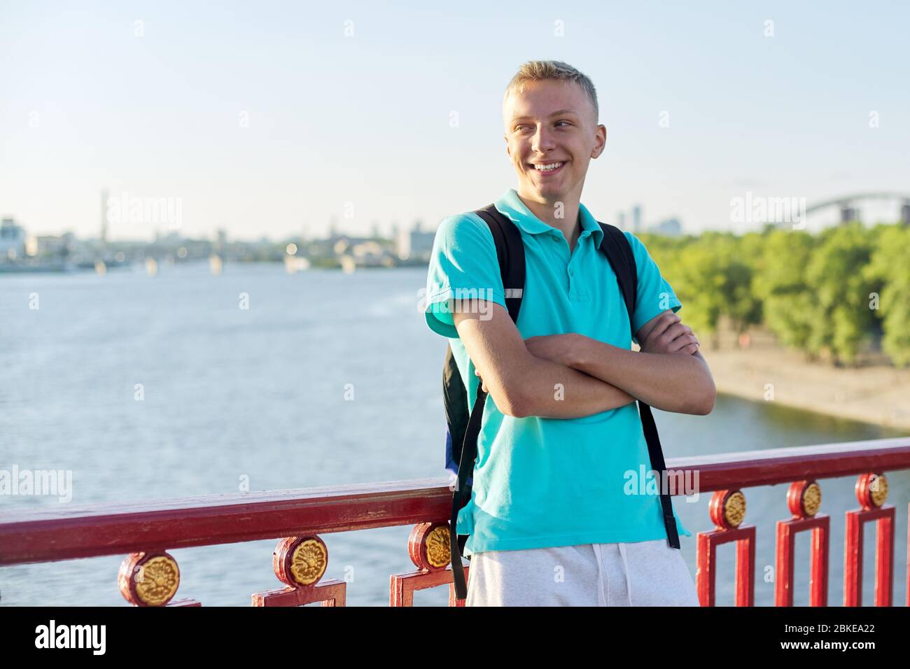 Portrait extérieur d'un adolescent souriant de 15 ans, âgé de 16 ans, avec bras croisés Banque D'Images