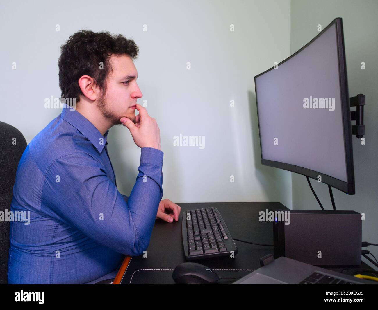 Jeune homme de programme caucasien pensant à un problème de travail. Concept de télétravail. Quarantaine. Banque D'Images