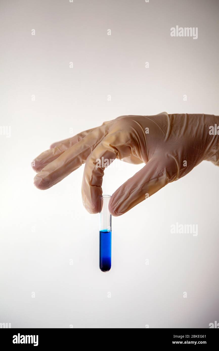 Flacon de maintien des mains avec gants et liquide bleu Banque D'Images