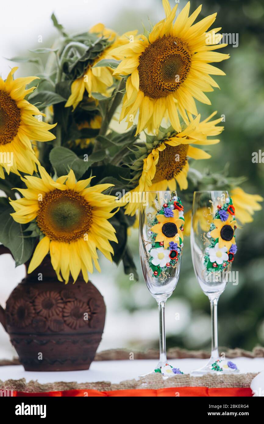 tournesols dans un vase à côté des verres à champagne Banque D'Images