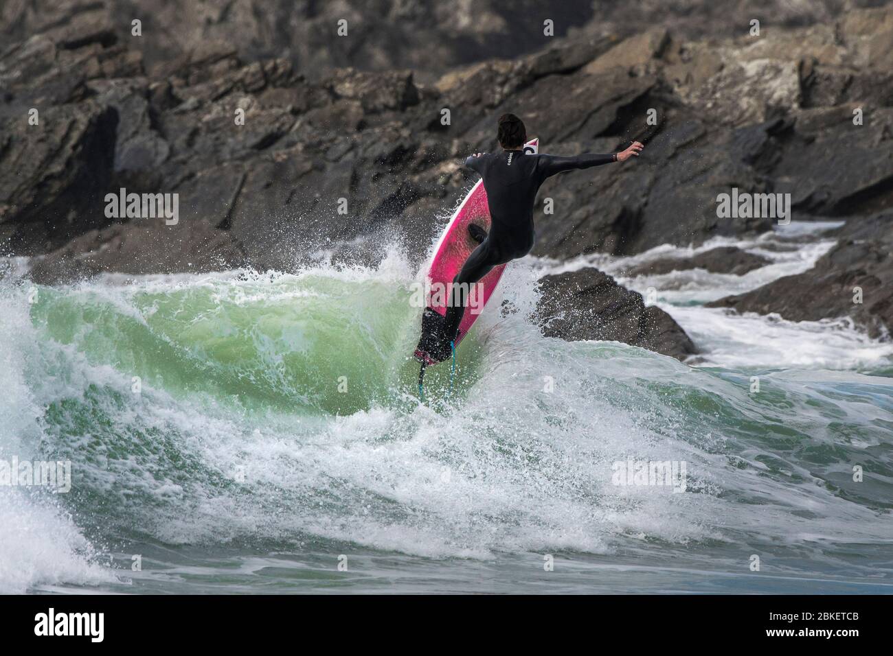 Une action spectaculaire en tant que surfeur se fait dans l'air à partir d'une vague à Fistral à Newquay, en Cornwall. Banque D'Images