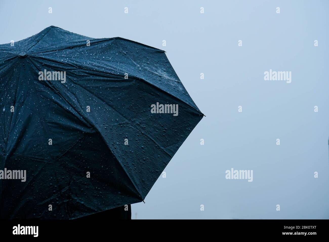 Seul homme debout sous la pluie avec un parapluie Banque D'Images