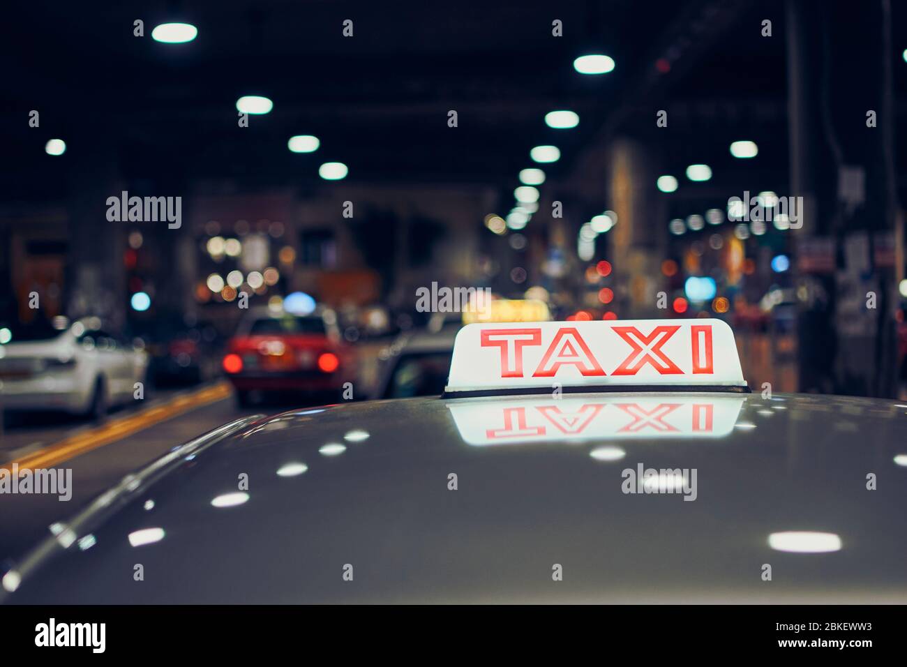 Panneau de taxi lumineux sur le toit de la voiture sur la rue de la ville la nuit, Hong Kong Banque D'Images