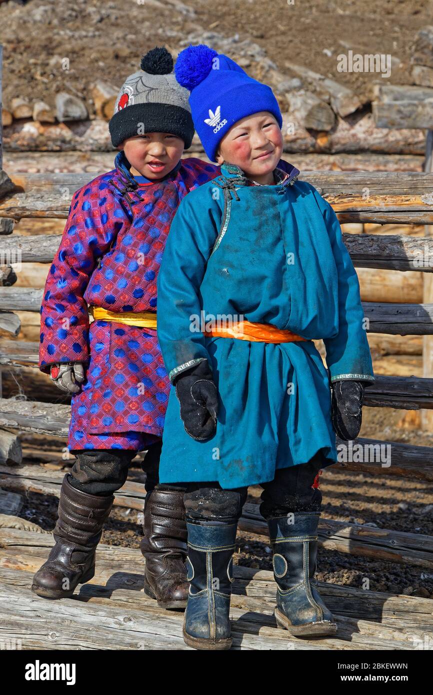 RENCHINLKHUMBE, MONGOLIE, 4 mars 2020 : enfants mongoles en robe traditionnelle sur une clôture de camp d'hiver. Banque D'Images