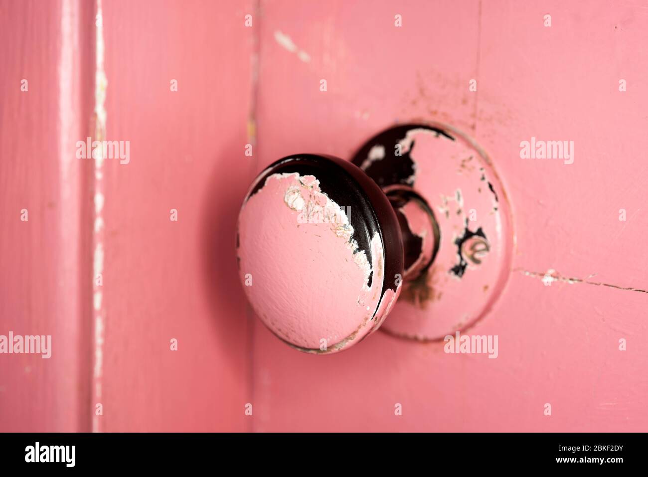 Peinture rose écaillée sur le bouton de porte Banque D'Images