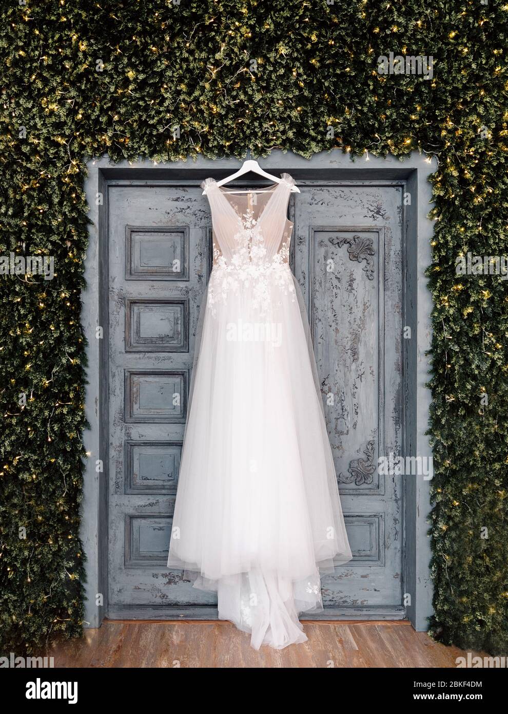 Accrochee A La Robe De Mariee La robe de mariage blanche de la mariée est accrochée sur le fond de la  porte, du boho et du style rustique Photo Stock - Alamy
