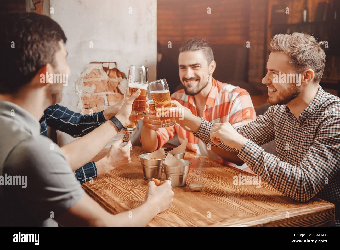 Les vieux amis joyeux et heureux boivent de la bière pression au bar du ...