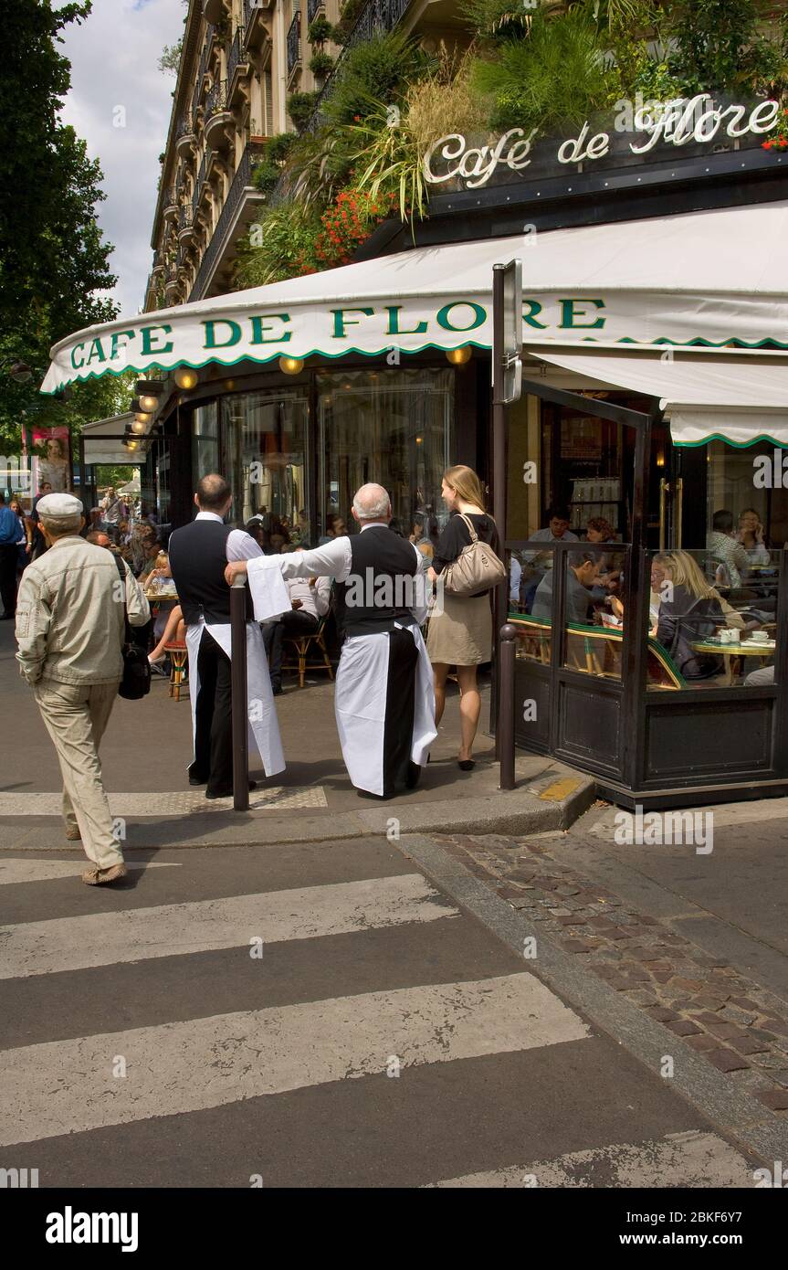 Les serveurs parlent à une jeune femme et à des personnes assis à l'extérieur du café de flore, boulevard St Germain, Paris, France Banque D'Images
