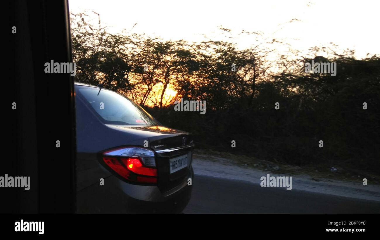 Lever, coucher de soleil et vue arrière de la voiture en mouvement Banque D'Images