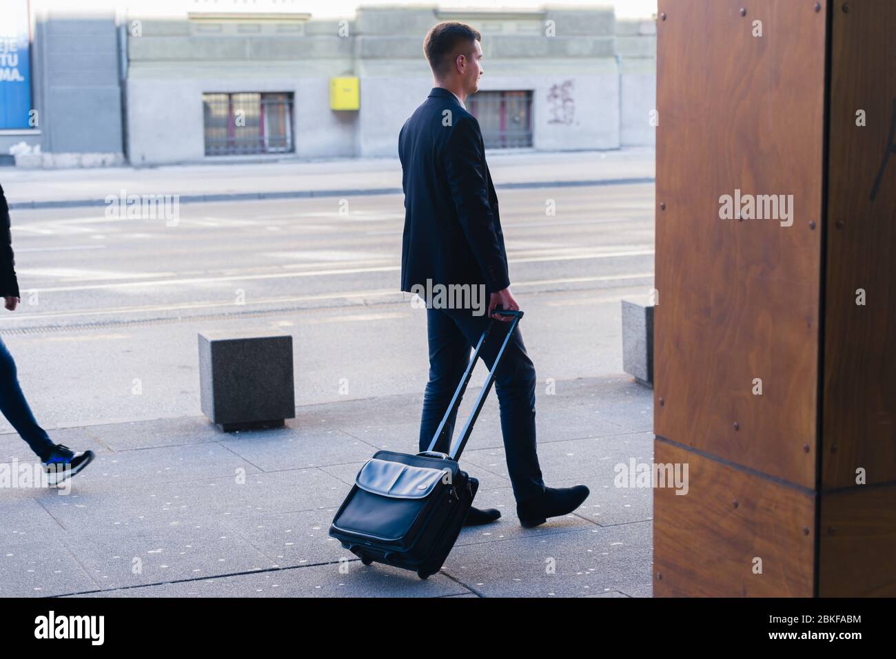 Gros plan photo un homme d'affaires formel traînant sa valise, sac à main, tirer le sac à travers un aéroport (gare) Banque D'Images