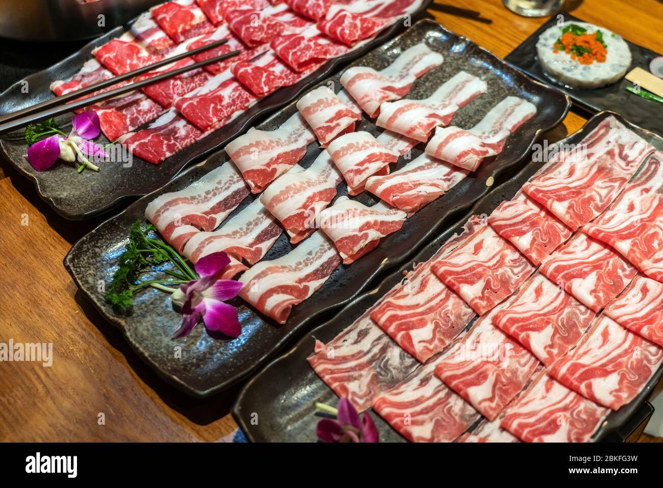 Sélection de plats de viande à cuire dans le restaurant Hotpot, y compris le bœuf, l'agneau et le porc. Toutes les tranches fines pour une cuisson rapide Banque D'Images