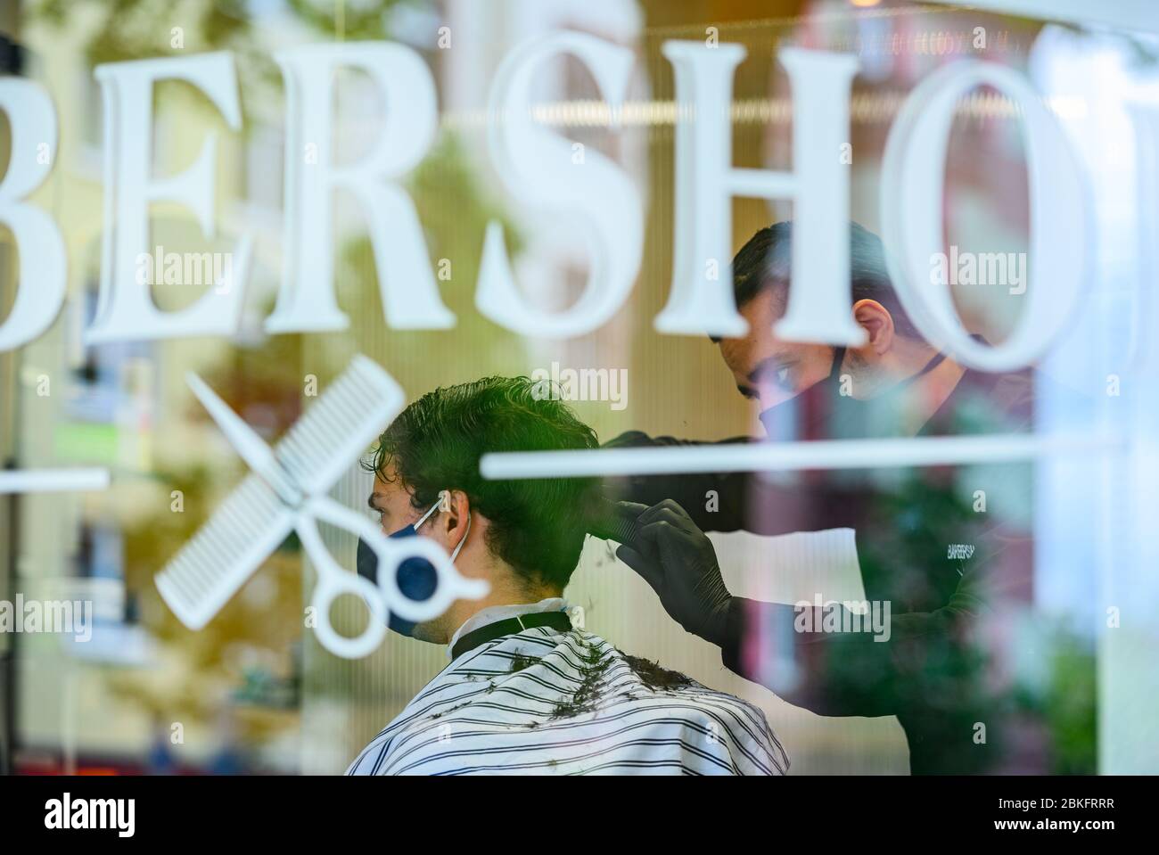 Mayence, Allemagne. 04 mai 2020. Un coiffeur coupe les cheveux d'un client dans le 'Barbershop' dans le centre-ville. La boutique du salon de coiffure est complètement réservée, les clients font la queue devant la boutique. Les terrains de jeux pour enfants et les équipements d'entraînement en plein air sont de nouveau ouverts, les coiffeurs sont autorisés à couper les cheveux à nouveau. Des règles d'hygiène strictes sont toutefois toujours applicables. Crédit: Andreas Arnold/dpa/Alay Live News Banque D'Images