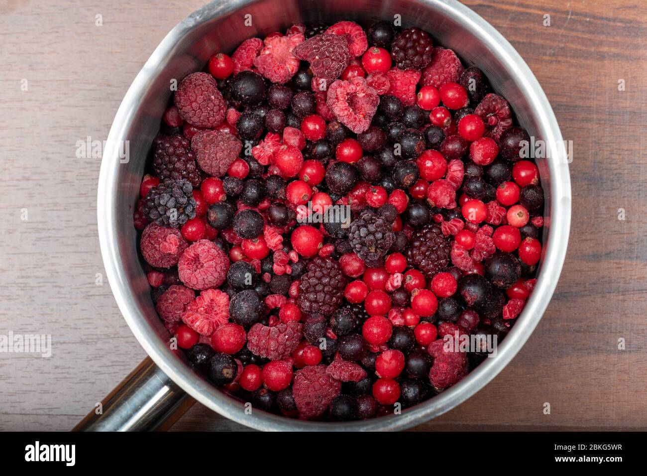 Assortiment de baies rouges congelées dans une casserole en métal Banque D'Images