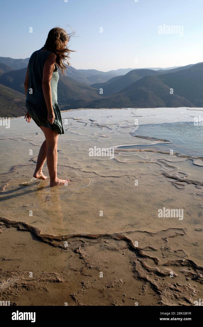 Femme marchant pieds nus dans les eaux peu profondes d'un petit lagon au site géologique de Hierve el Agua. Banque D'Images