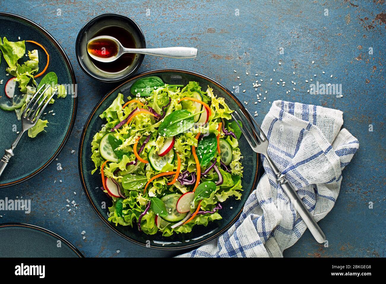 Repas de salade de laitue verte avec légumes frais mélangés sur fond bleu de table Banque D'Images