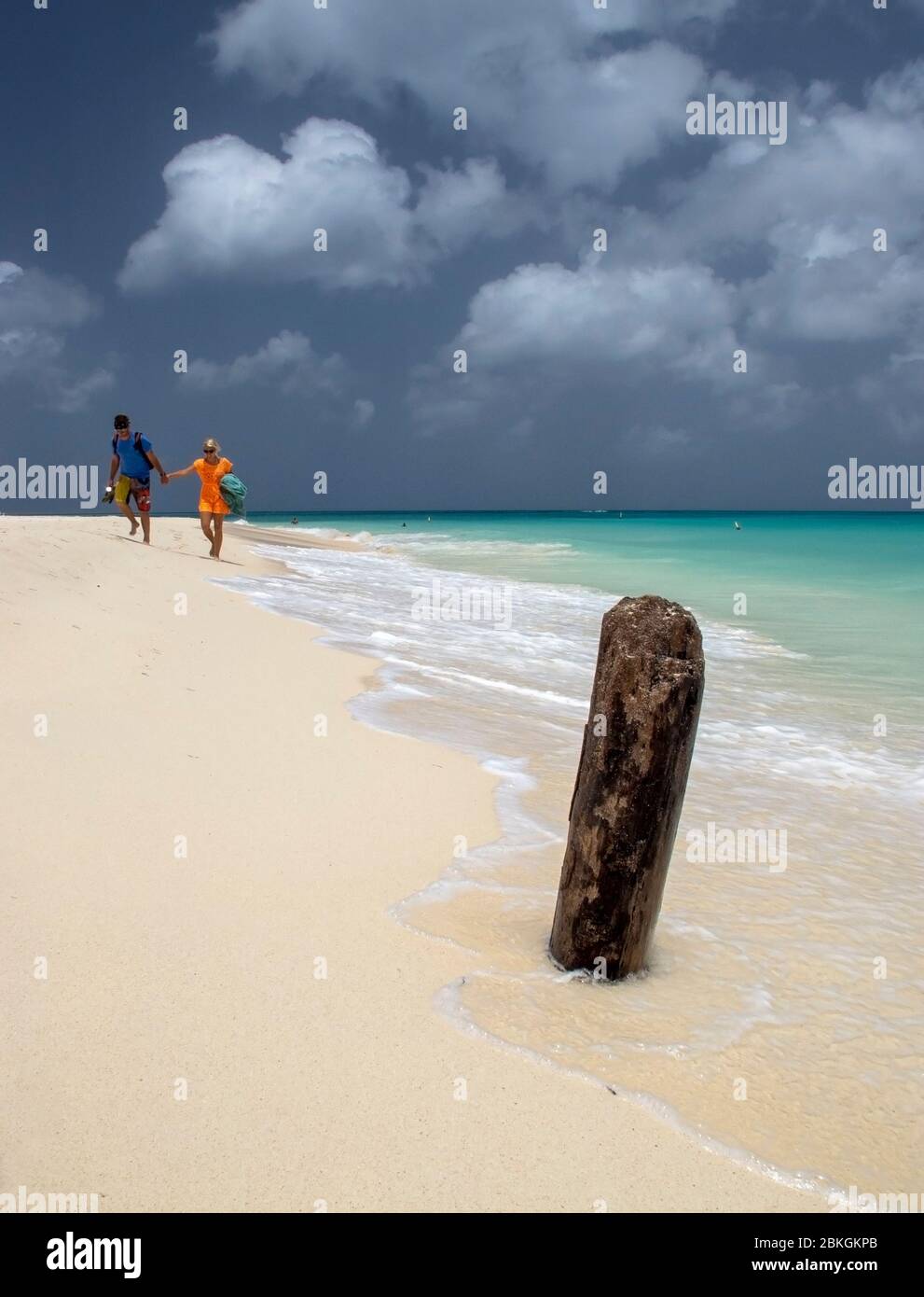 Deux personnes marchant main dans la main le long d'une plage d'Eagle. Aruba, Antilles néerlandaises, Caraïbes Banque D'Images