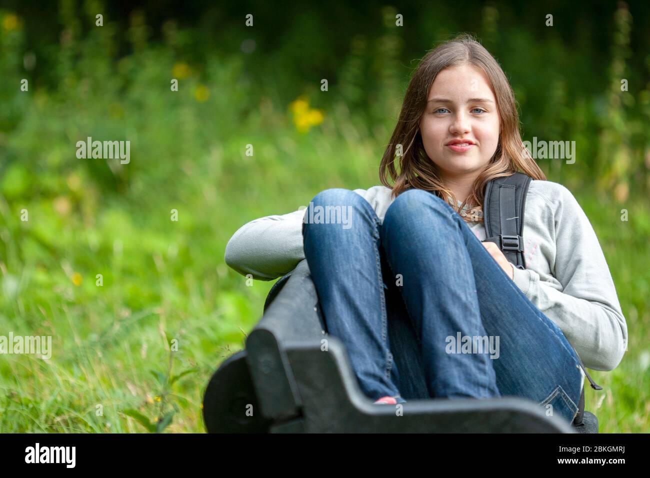 Un jeune adolescent s'est assis sur un banc dans la campagne anglaise, Lancashire, Angleterre, Royaume-Uni Banque D'Images