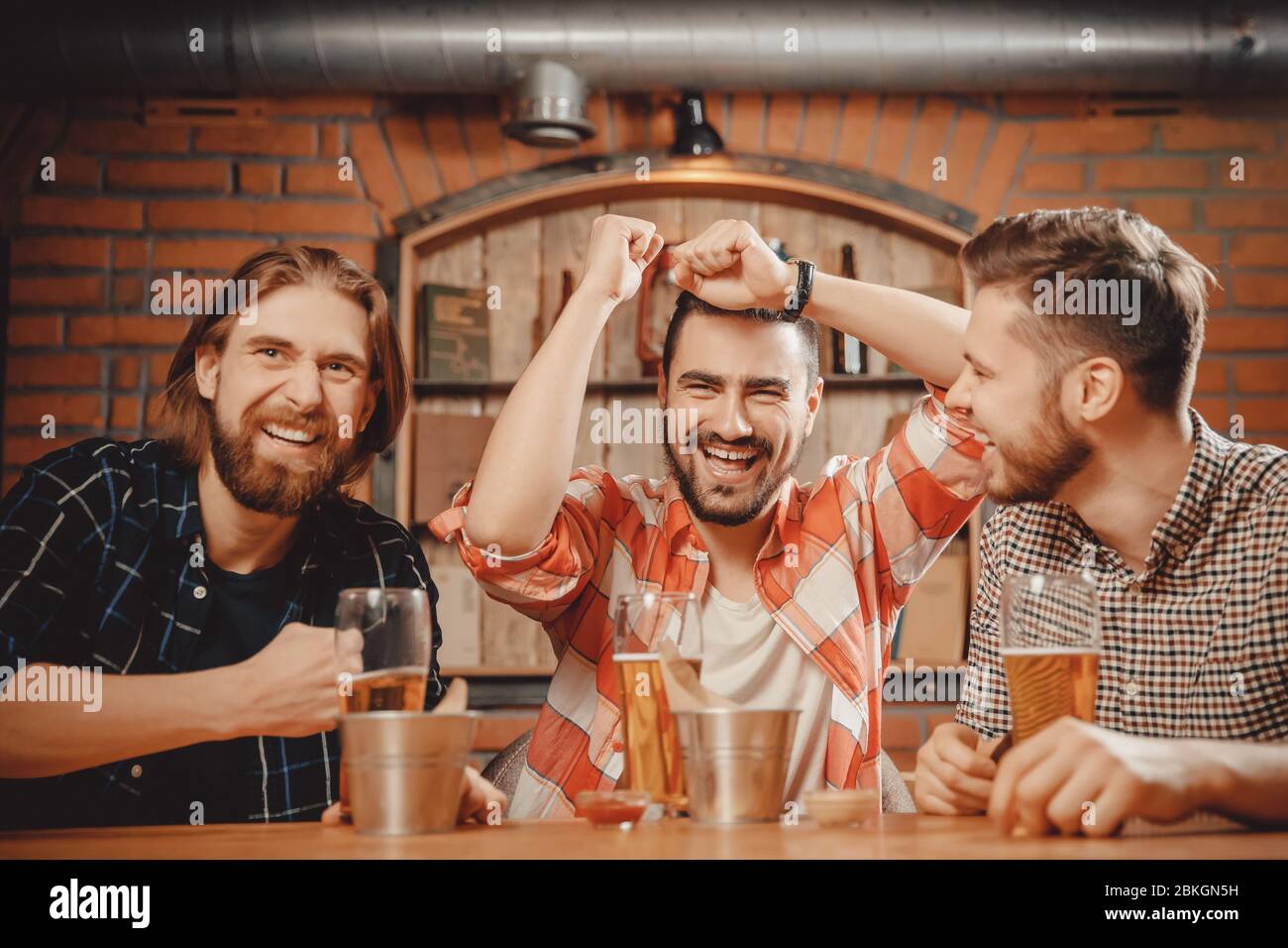 Des amis joyeux les fans de hommes regardent les matchs sportifs à la ...