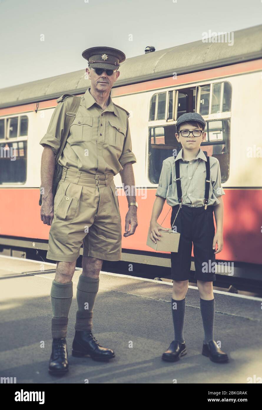 Severn Valley Railway 1940 guerre la seconde Guerre mondiale événement d'été Royaume-Uni. Rétro vintage vue avant années 1940 homme en uniforme et jeune garçon debout en train, plate-forme de gare. Banque D'Images