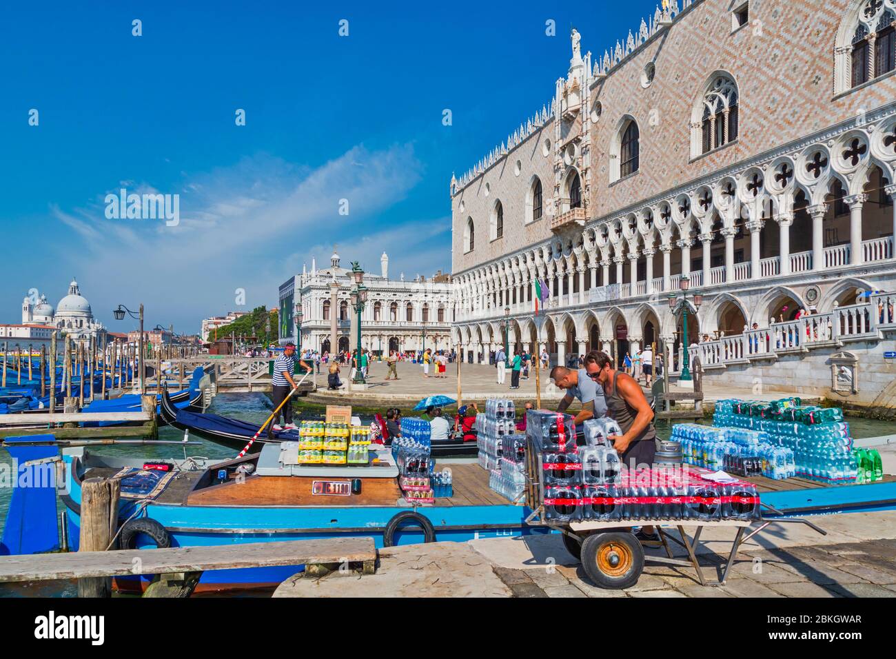 Venise, Italie. Déchargement de marchandises d'une barge à côté du Ponte di Rialto. Le Palais Ducale (Palais des Doges) est en arrière-plan. Patrimoine mondial de l'UNESCO Banque D'Images