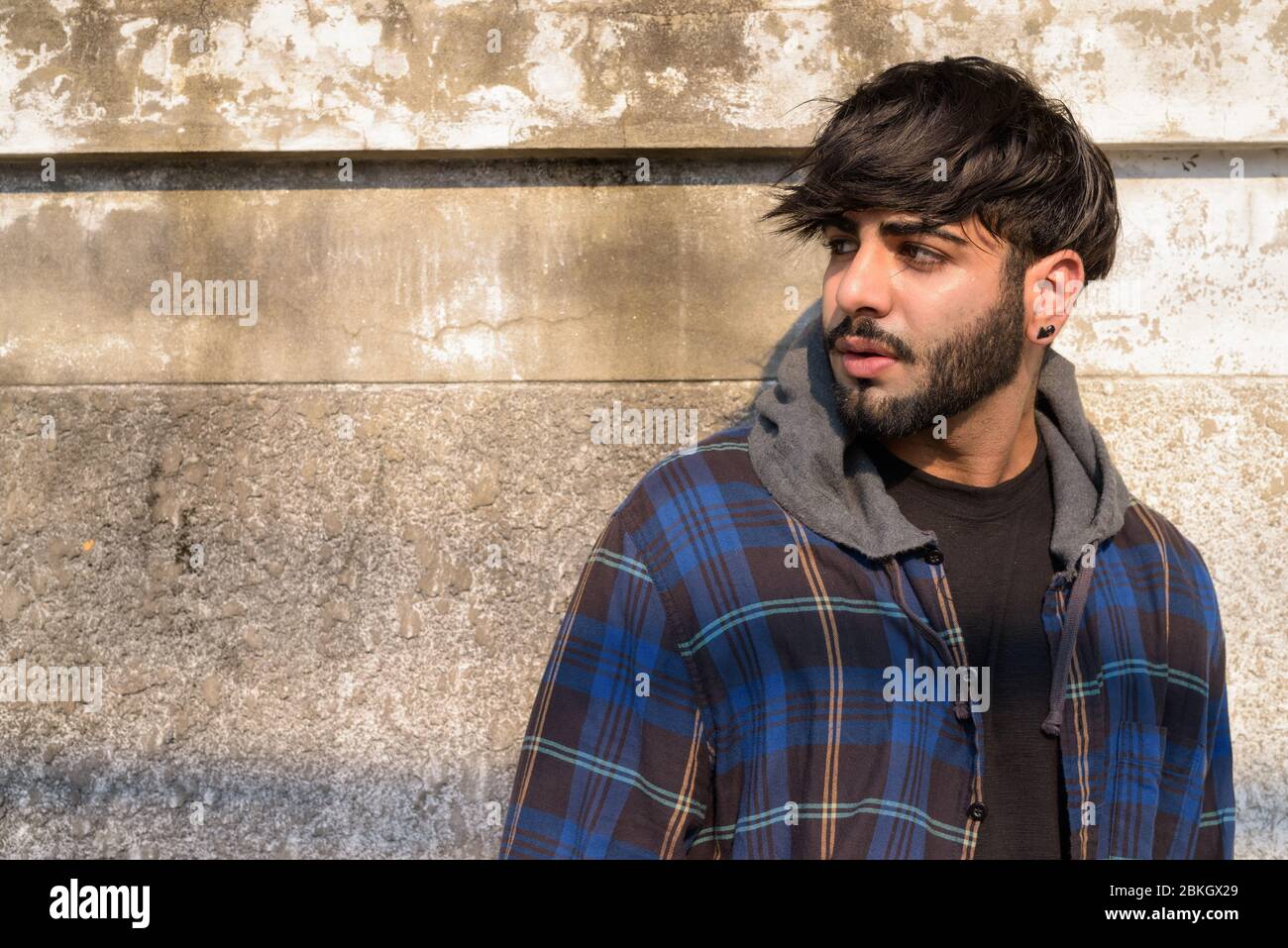 Jeune homme hippster indien barbu pensant dans les rues Banque D'Images