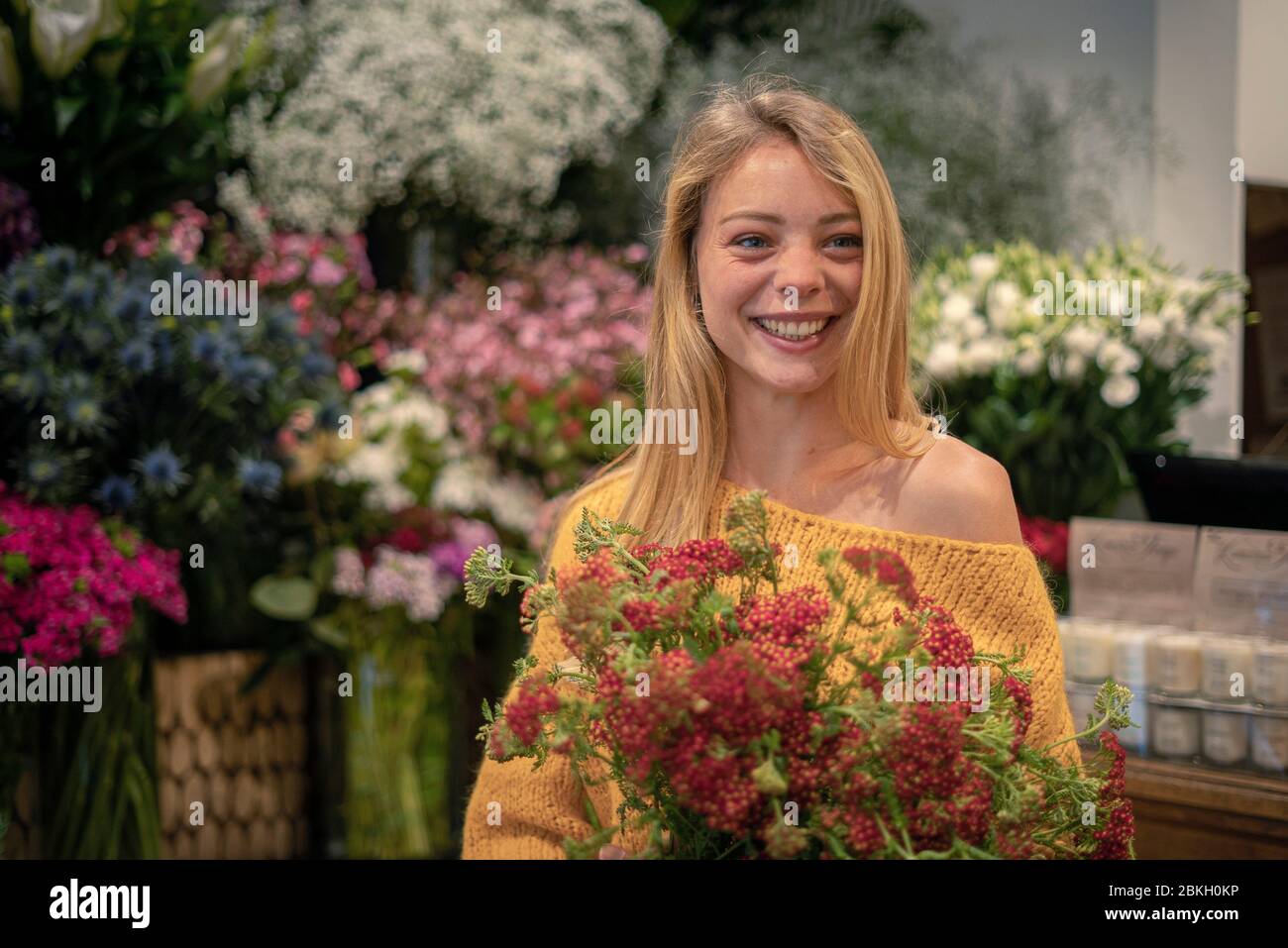 Jeune femme debout dans un fleuriste Banque D'Images