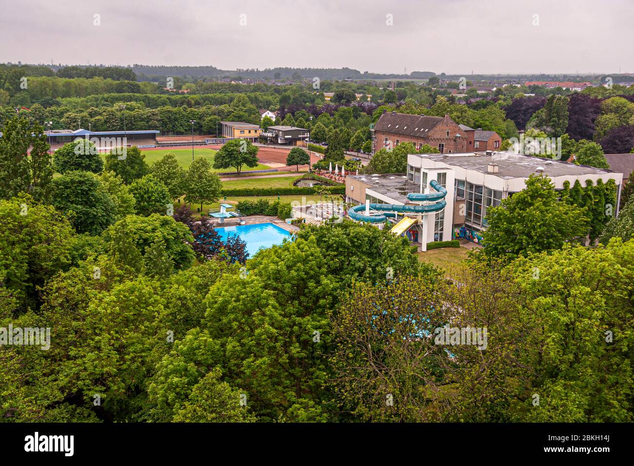 La vieille piscine extérieure et intérieure avec toboggan devant le