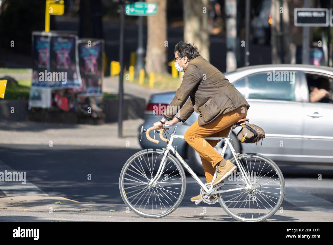 Un jeune homme protégé par un masque pratiquant le sport à vélo dans les rues de Providencia pendant la maladie d'infection à coronavirus COVID-19 Banque D'Images
