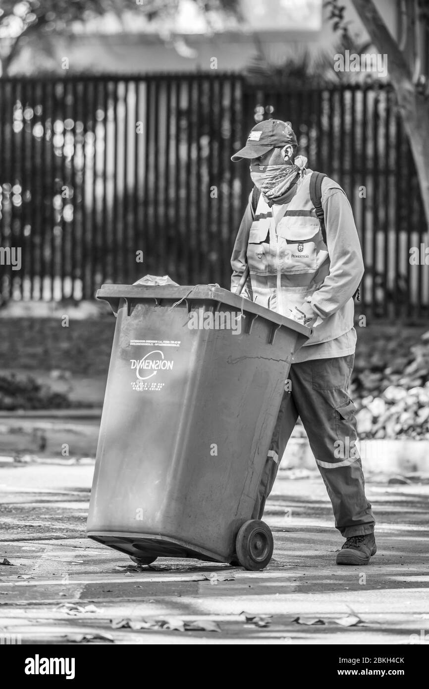 Travailleur de nettoyage immigrant inquiet en travaillant sur les rues de Santiago nettoyage pendant l'infection à coronavirus COVID-19 avec protection précaire Banque D'Images